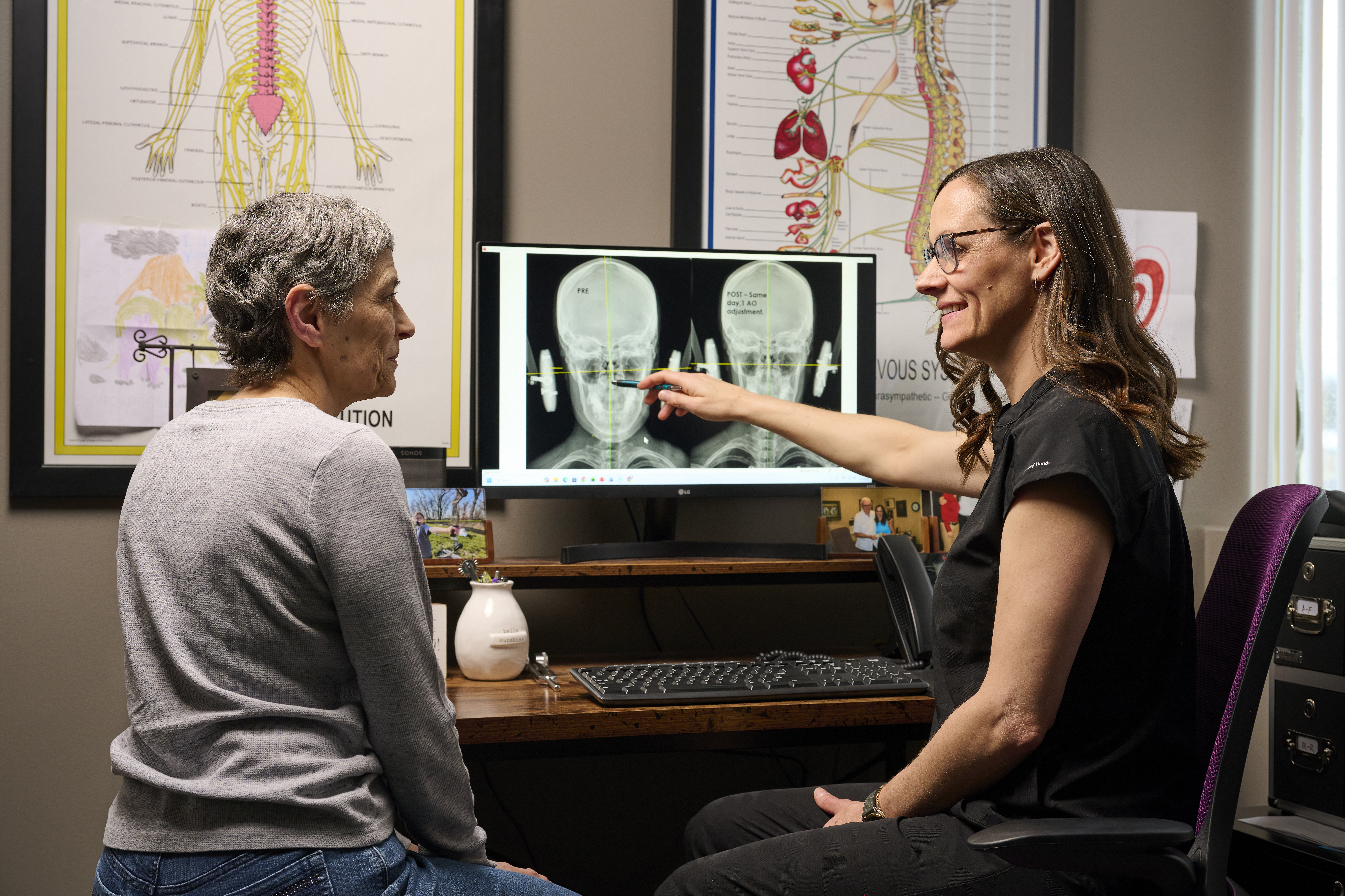Des Moines chiropractor Dr. Laurel Griffin reviewing upper cervical imaging with a patient at Precision Chiropractic West